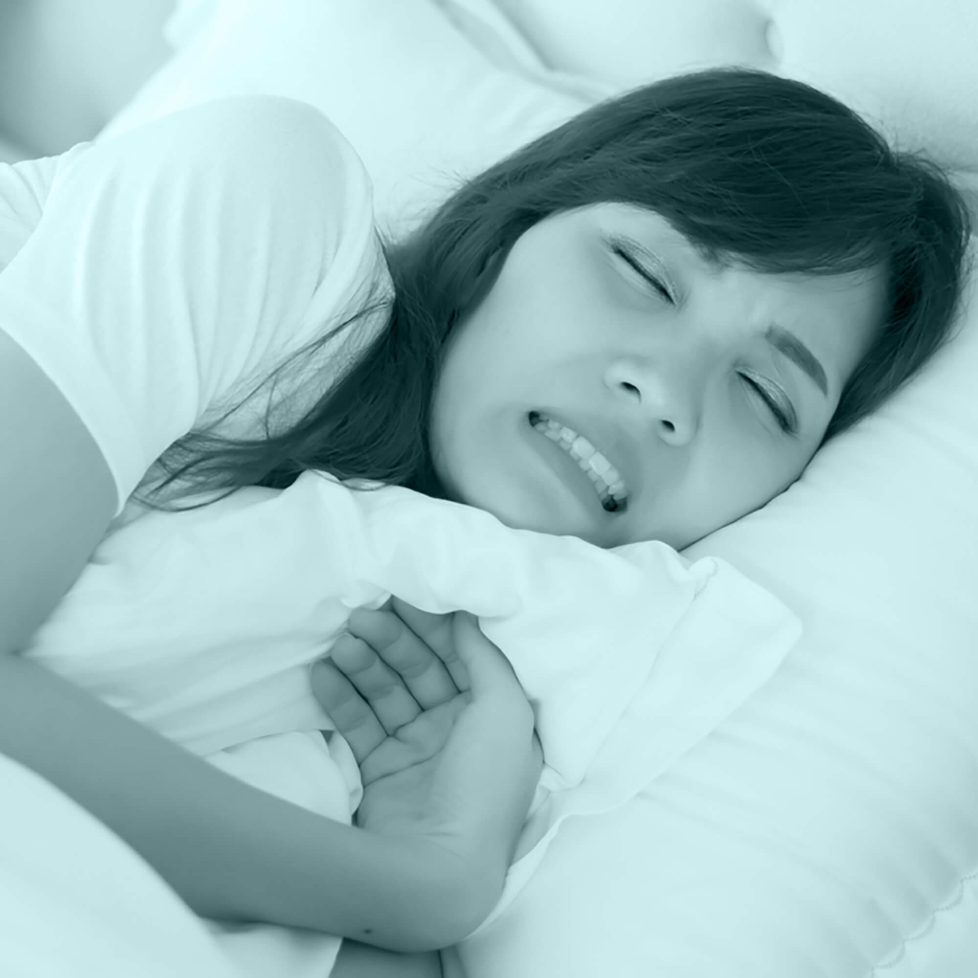 girl lying on bed with her teeth shut tight