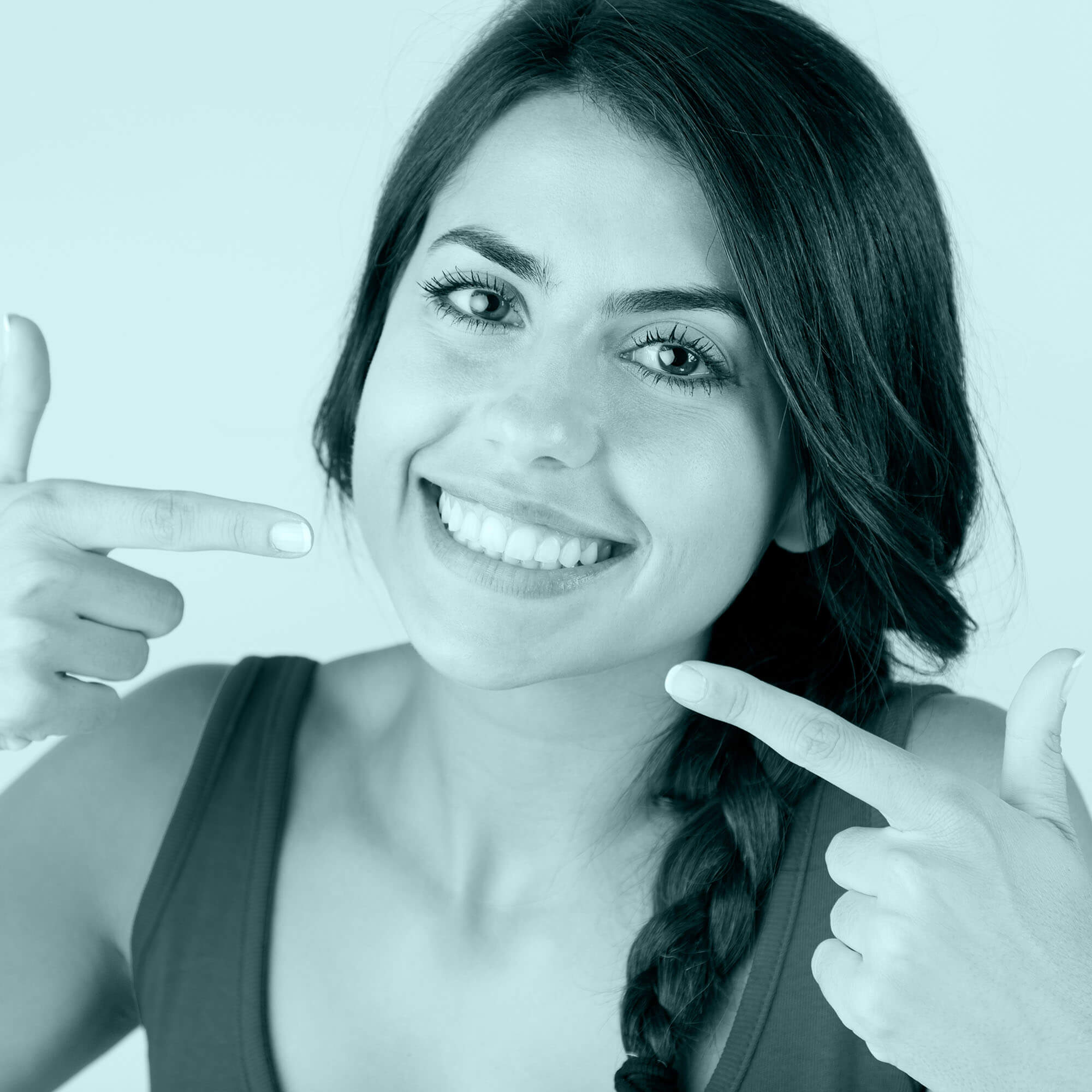 photo of a smiling girl pointing at her mouth with using fingers of both hands