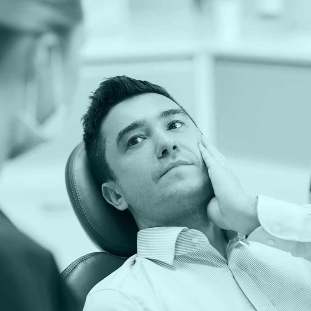 photo of a man touching his cheek, a female dentist looking at the man