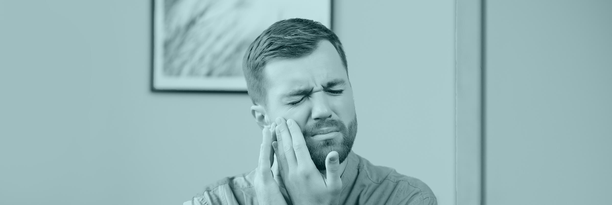 image of a man holding his cheek with both hands