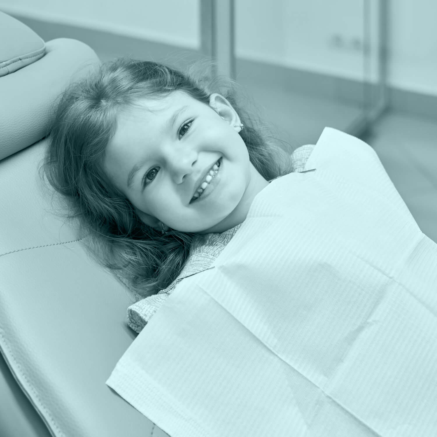 small girl lying on a dentist chair smiling