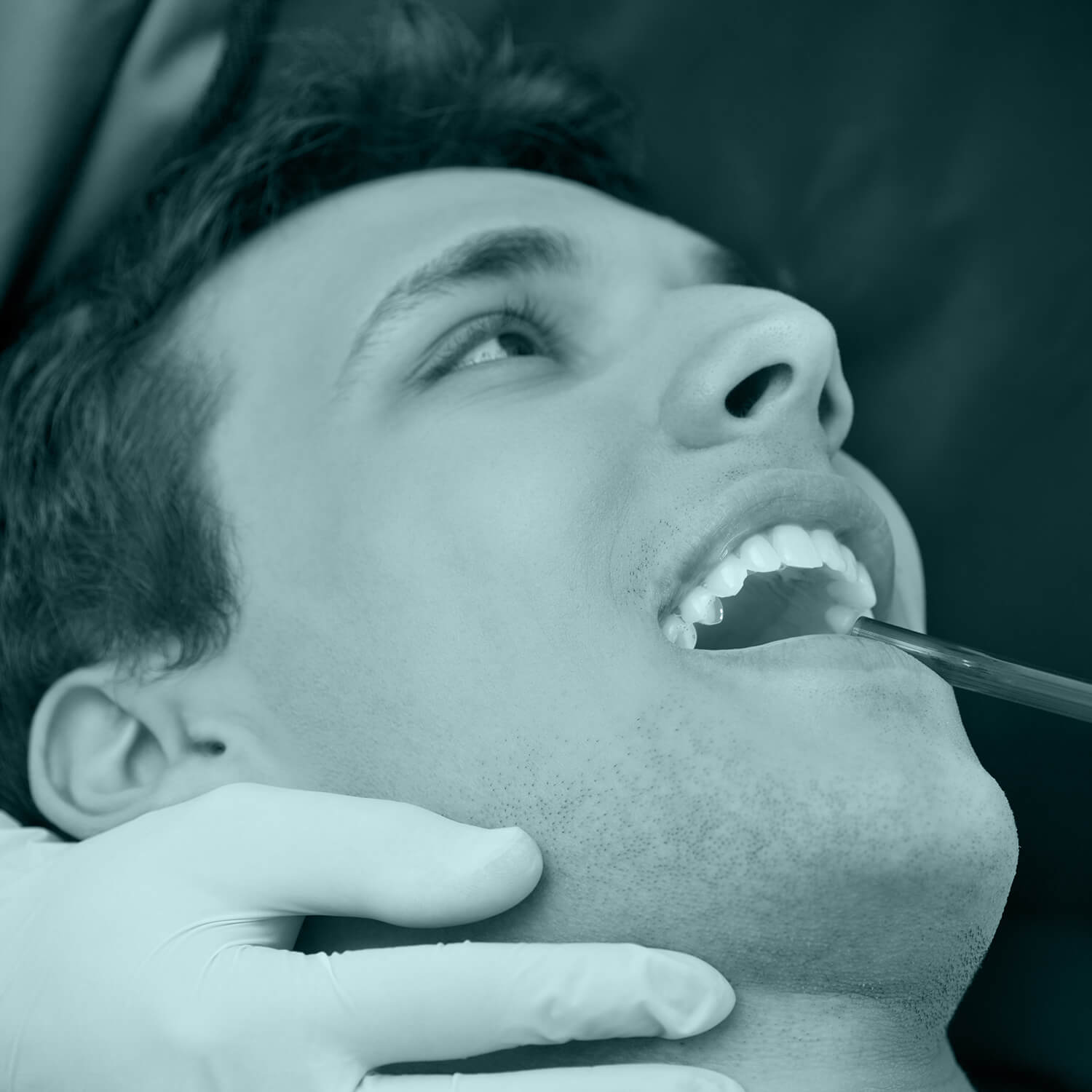 man at a dentist with his open mouth and the laser light treatment